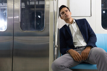 male businessman sleeping inside the subway train