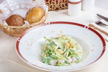 Salad with pineapples and herbs with mayonnaise. There is bread in the basket