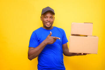 An African dispatch man with face cap, pointing to the boxes he is carrying on his shoulder