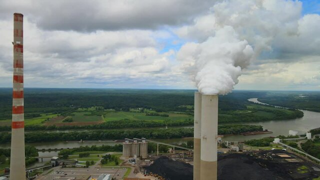 Close up aerial orbit of smokestacks at fossil plant