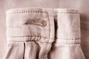 Elements of tailoring a denim beige shirt close-up. Pockets, buttons, and sleeves on a denim shirt. Modern comfortable denim clothing concept