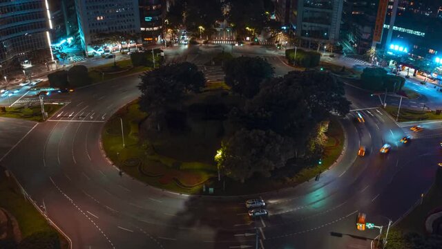 Aerial hyperlapse of driving cars at renai roundabout in taipei, Taiwan. Traffic on road surrounded by lighting skyscraper buildings,taiwan