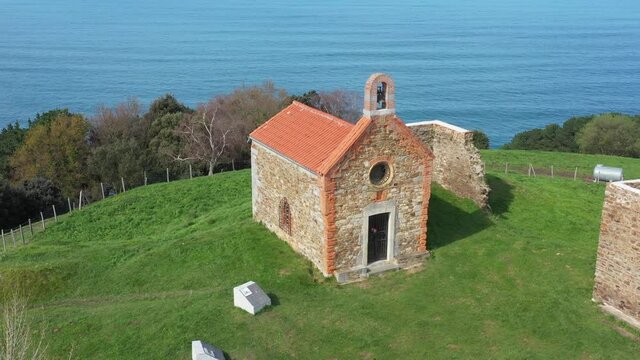 Aerial drone view of a hermitage next to the Cantabrian Sea in Deba in the Basque Country