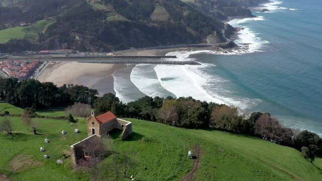 Aerial drone view of a hermitage next to the Cantabrian Sea in Deba in the Basque Country