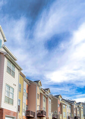 Vertical Exterior view of townhouses in the valley under bright clouds and vivid blue sky