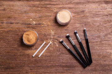 Mineral powder foundation with brushes on a wooden background. Eco-friendly and organic beauty products