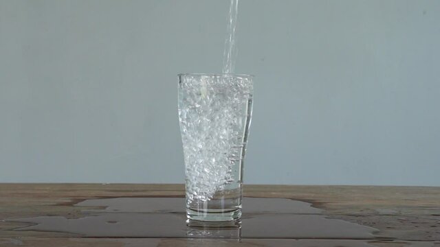 slow motion of pouring water into tall glass. Full HD