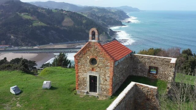 Aerial drone view of a hermitage next to the Cantabrian Sea in Deba in the Basque Country