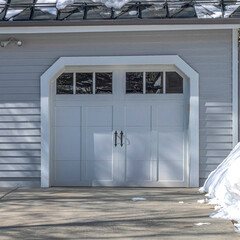 Square Garage door and front door of a home with white wall in Park City neighborhood