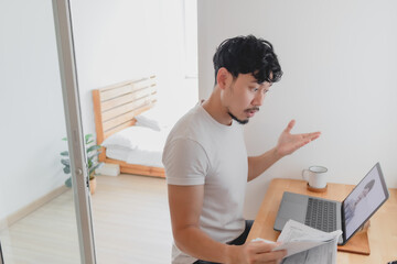 Asian man attend a meeting conference with his colleague while work from home.