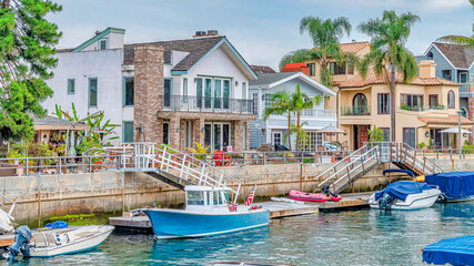 Fototapeta na wymiar Pano Leaisure boats docked on canal in Long Beach neighborhood with resort like views