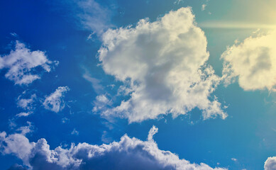 Naklejka na ściany i meble Blue sky with cumulus clouds and sun background