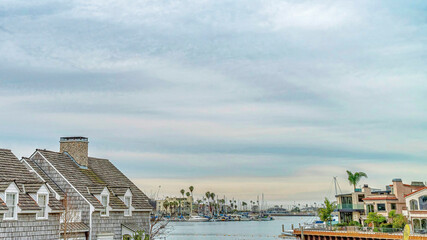 Fototapeta na wymiar Pano Blue sky and puffy clouds over scenic waterfront neighborhood of Long Beach