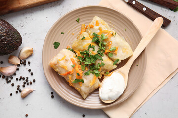 Plate with tasty stuffed cabbage rolls on light background