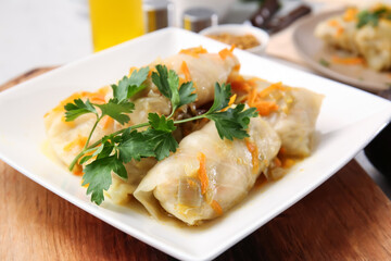 Plate with tasty stuffed cabbage rolls on table