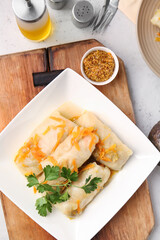 Plate with tasty stuffed cabbage rolls on light background
