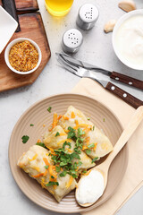 Plate with tasty stuffed cabbage rolls on light background