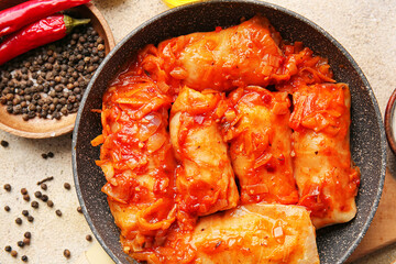 Frying pan with tasty stuffed cabbage rolls on light background