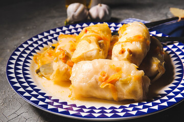 Plate with tasty stuffed cabbage rolls on grey background