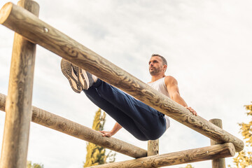 Male athlete exercising on a wooden structure