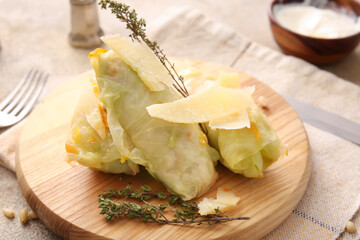 Board with tasty stuffed cabbage rolls on light background