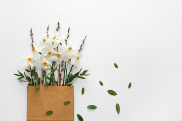 Bag with beautiful daffodils on white background