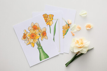 Beautiful greeting cards and narcissus flower on light background