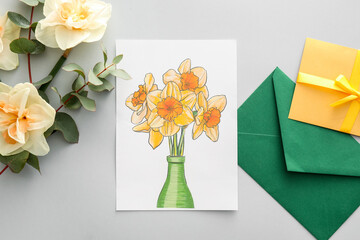 Beautiful greeting card, envelopes and narcissus flowers on grey background
