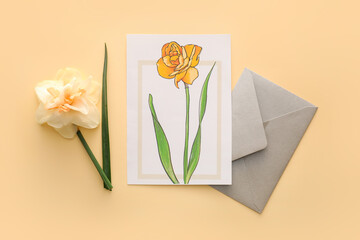 Beautiful greeting card, narcissus flower and envelope on color background