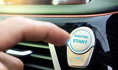 The driver uses his finger to press the button to start the electric car's drive