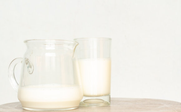 Pure milk drinks in clear jars and bottles are naturally healthy foods placed on a desk wood on a blue background