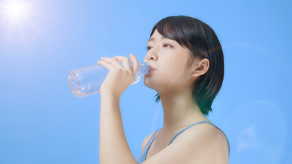 ペットボトルの水を飲む女性　水分補給