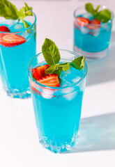 close up of blue juices with strawberries, mint and ice