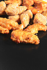 Tasty crispy deep fried chicken wings and legs over black. Beer snacks, dinner set for party.