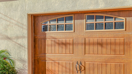 Pano Brown glass paned wooden garage door of home in Huntington Beach California
