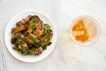 Homemade baked Garlic Parmesan Chicken Wings with Cold Beer, top view. Flat lay, overhead, from above.