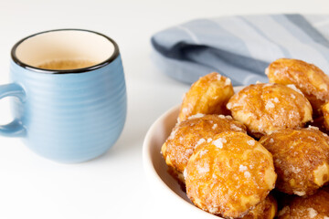 french chouquettes puffs with perles of sugar on plate with blue cup of coffee. Choux pastry Classic French bakeries. 