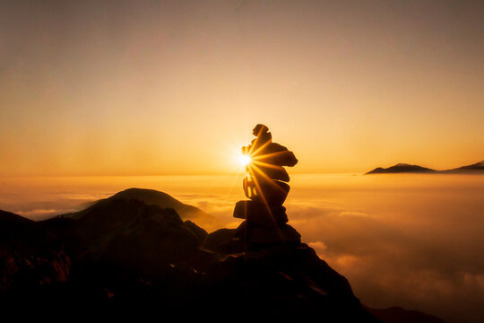 Beautiful sunset in the mountains, silhouette of stone column called Apacheta in the Andean zone of Peru.