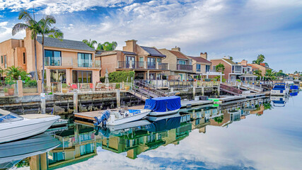 Pano Amazing waterfront landscape with houses docks and boats under cloudy blue sky