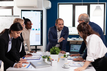 Team of diverse startup company colleague entrepreneur meeting in professional workplace broadroom. Multiethnic colleagues working planning success financial strategy discussing in office