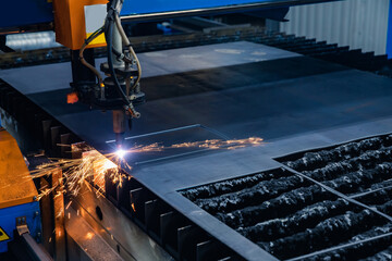 CNC plasma cutting metal iron material with sparks, industry background blue and orange color