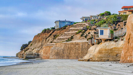 Pano Mountain houses overlooking ocean and beach with cloud and sky background