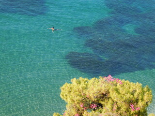 A swimmer in clear water on the coast of the island of Poros, Greece