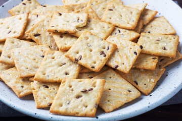 Delicious healthy cookies crackers with flax seeds and sesame seeds on a plate. Background of a healthy snack food, close up.