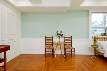 테이불과 의자, 그리고 그린벽과 우드 바닥이 있는 리빙룸