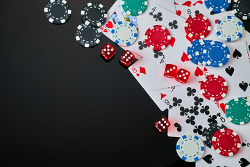 Casino chips, playing cards and dices on dark reflective background