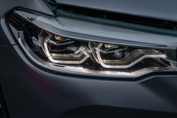 Fototapeta premium Close up part of automobile. The headlight of a modern luxury car from a close angle.