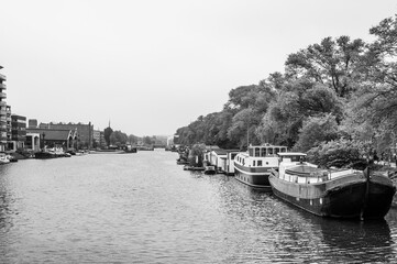 Naklejka premium AMSTERDAM, NETHERLANDS. JUNE 06, 2021. Beautiful view to a shipping channel and bridges. Black and white photography