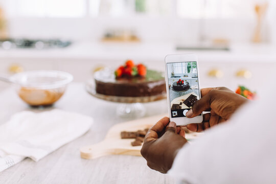 Closeup of woman taking photos of cake with mobile phone