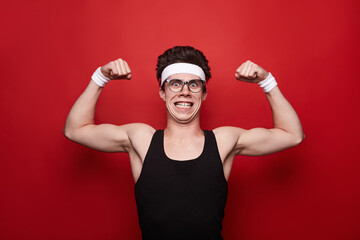 Funny man showing biceps on red background